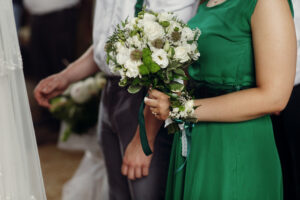 Bridesmaid dresses in Franklin, TN, stylish bridesmaid standing holding a wedding bouquet in church.