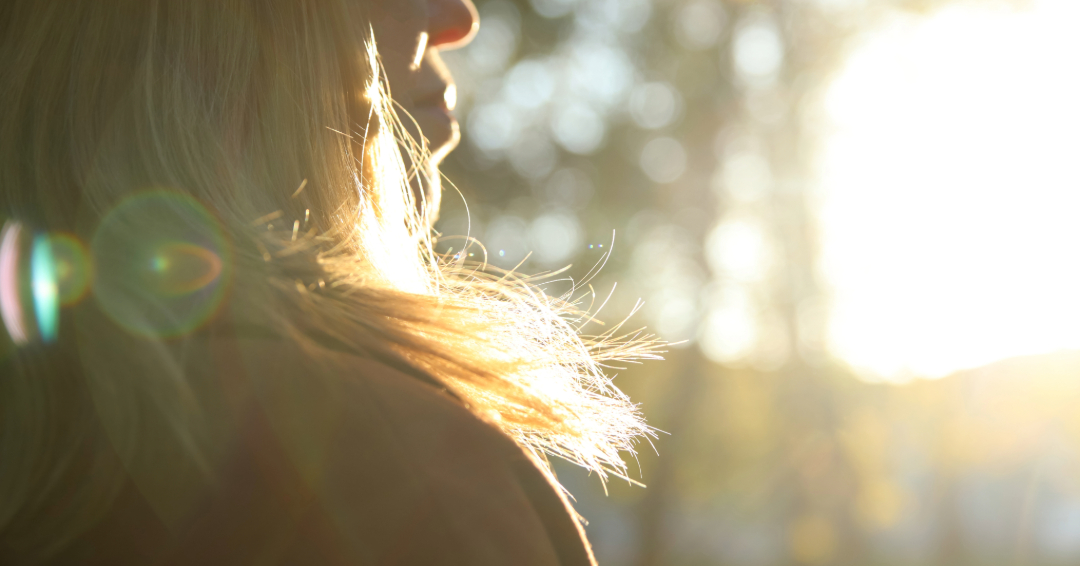 A woman with blonde hair in the sunlight.