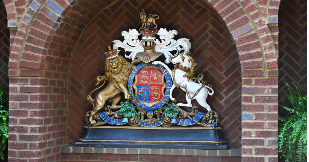 A photo of Castle Gwynn's Crest, displayed on the exterior of the castle, featuring a lion and a unicorn.