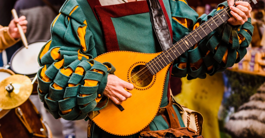 Tennessee Renaissance Festival, medieval troubadour playing an antique guitar. Image Resized.