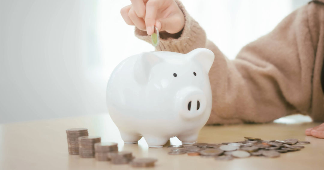 Putting money into a piggy bank: saving money in Williamson County, Tennessee.