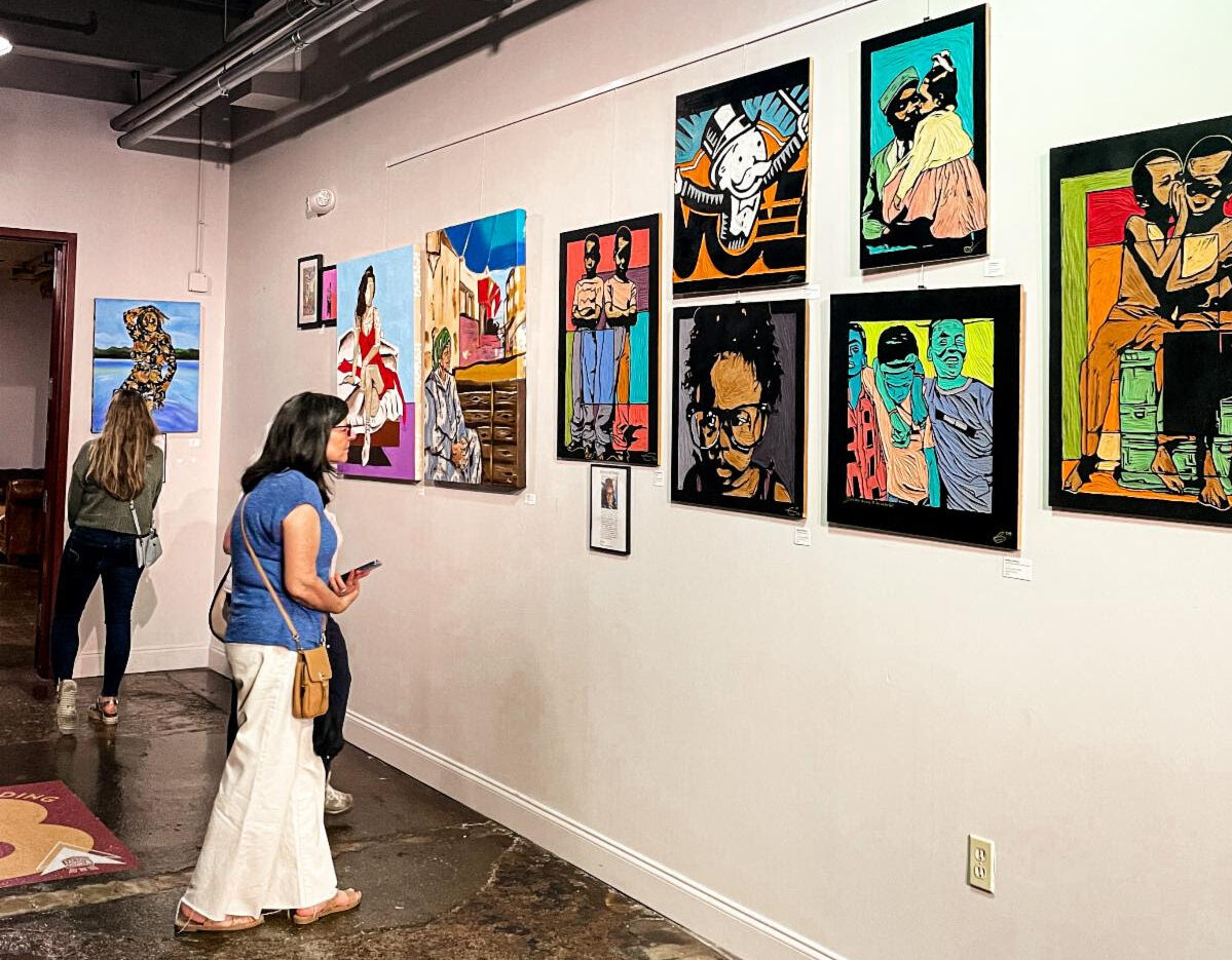 Visitors admire colorful paintings on display at The Factory at Franklin, highlighting the city’s local art and creative community.