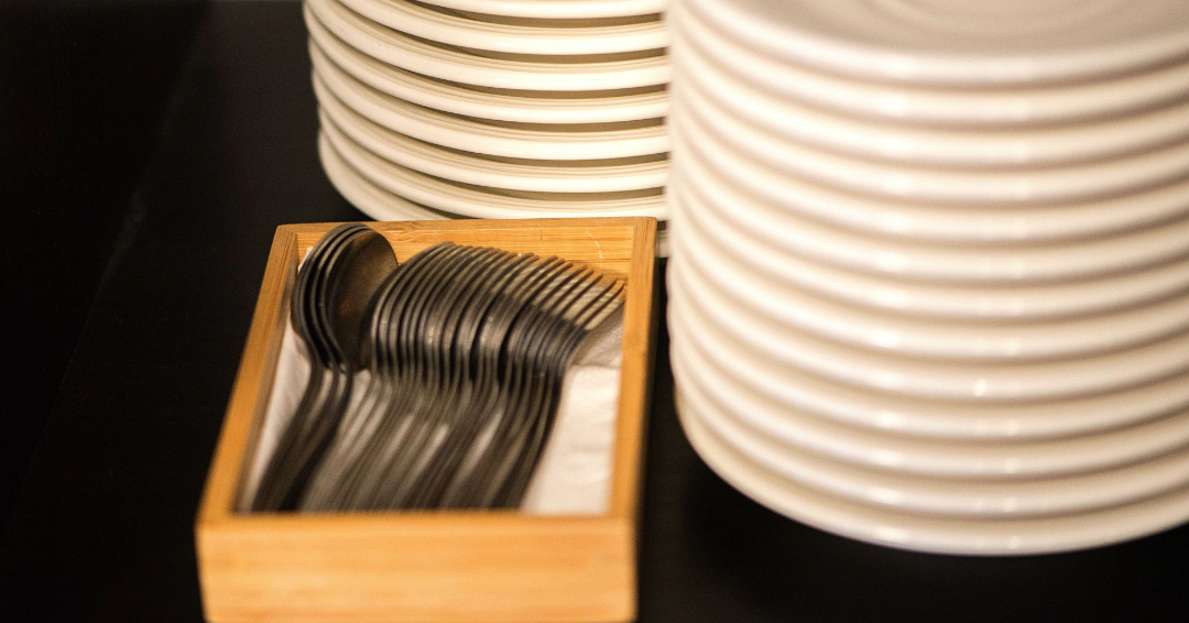Forks and plates, neatly stacked and ready to be served, representing dining options in Franklin, Tennessee. 