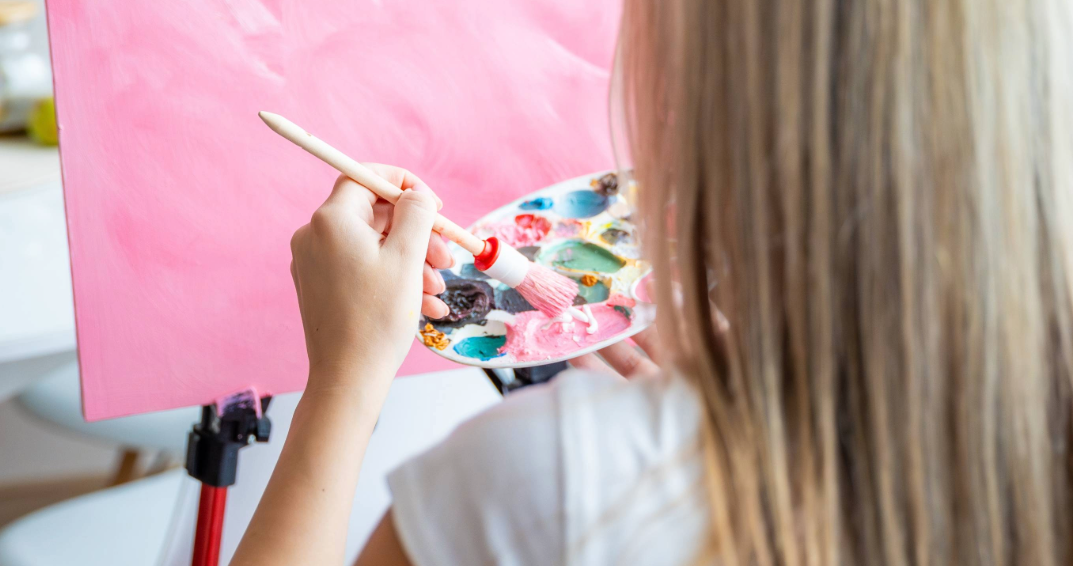 A woman pursuing art and hobbies in Franklin and Williamson County, Tennessee, by painting a canvas.