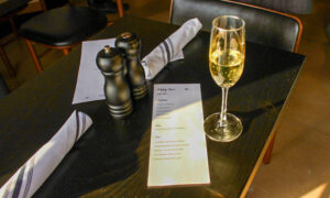 Happy Hour menu at Karrington Rowe in Brentwood, TN, and a glass of champagne on a table.